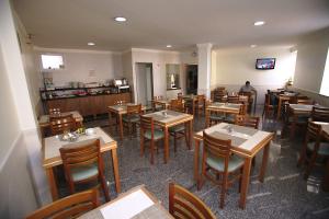 圣保罗西内拉迪亚酒店的一间带桌椅的餐厅和一间厨房内的男士餐厅
