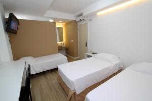 弗洛里亚诺波利斯唐泽佩酒店的一间酒店客房,设有两张床和电视