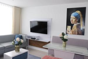 巴兰基亚Apartamento a 15 min de BUENAVISTA cerca a UNINORTE y CLINICA PORTOAZUL AA 2TV y parqueadero incluido的客厅配有沙发和一幅女人画