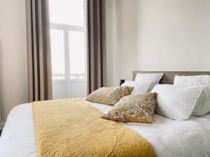Rilly-la-MontagneLa Cour Tellier的一张带白色床单和枕头的床以及窗户