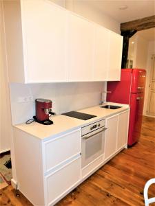 潘普洛纳AT SARASATE LUXURY的厨房配有白色橱柜和红色冰箱