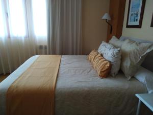 曼萨纳雷斯Área de Servicio El Cruce的一间卧室配有一张大床和枕头