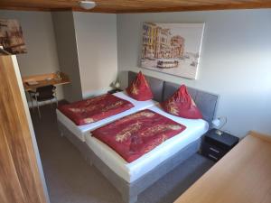 Wimpassing移动客房酒店的一间卧室配有红色枕头的床