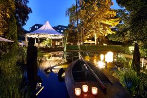 居特斯洛居特斯洛公园酒店的一条在池塘里放蜡烛的小船