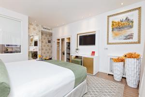 马德里玛尤拉泽格酒店的白色卧室设有一张大床和电视。