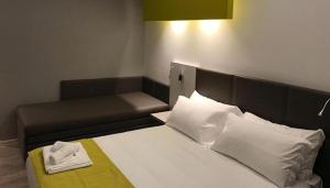 里米尼蒙马特酒店的一间卧室配有一张床和一张沙发