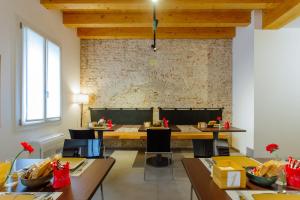 帕多瓦Dadi Home Camera 5的一间设有桌椅的用餐室和砖墙