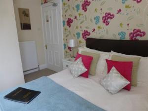 康威Bryn Derwen Guest House的一间卧室配有带粉色和白色枕头的床