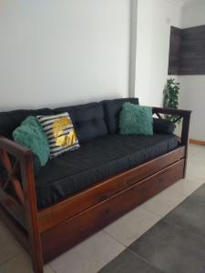 伊瓜苏港Santino Apart的一张黑色沙发,里面配有枕头