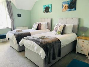 威廉堡Whinburn Guest House的一间卧室配有两张带毯子的床
