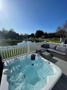 波克灵顿Lakeside Retreat Lodge With Hot Tub的甲板上的一个按摩浴缸