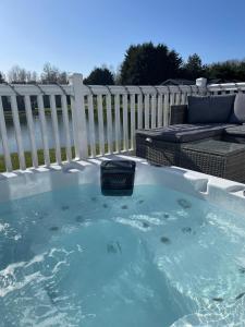 波克灵顿Lakeside Retreat Lodge With Hot Tub的后院的按摩浴缸,带有围栏