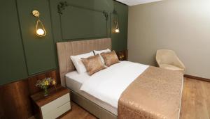 特拉布宗Bayrak Grand Hotel的一间卧室配有白色的床和绿色的墙壁
