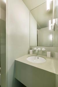 卡斯卡伊斯Jardim Suites by Olala Homes的白色的浴室设有水槽和镜子
