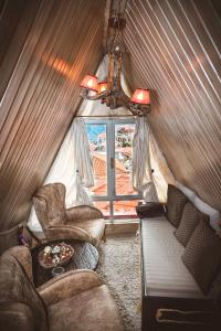 阿拉霍瓦Lykovrisi Guest House的客厅配有沙发和帐篷内的椅子