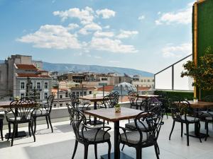 雅典Athens City View Urban Suites的阳台的天井配有桌椅