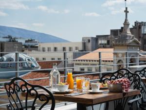 雅典Athens City View Urban Suites的阳台上的桌子上摆放着食物和饮料