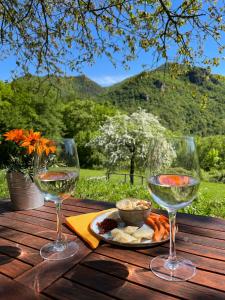 托斯科拉诺-马德尔诺Agriturismo San Lorenzo di Persegno的木桌旁放两杯葡萄酒