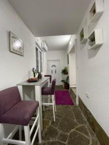 威尔帕扎JOCKER的客厅配有桌子和紫色椅子
