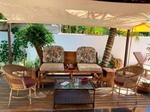 布希奥斯Loft a 600 metros da praia c piscina em Buzios RJ的庭院配有桌椅和遮阳伞。