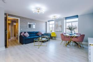 利兹Stunning Apartment - 10 Minutes From Leeds的客厅配有蓝色的沙发和桌子