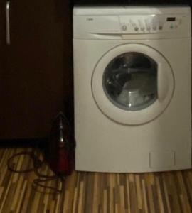 奥拉迪亚TALINA Apartament的洗衣机位于地板上,配有电话