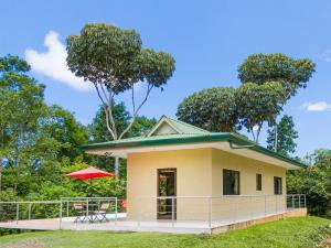 曼努埃尔安东尼奥Toucan Villa Newer with WiFi & Pool - Digital Nomad Friendly的一座黄色的小房子,配有红伞