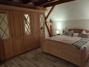 EberhardzellSonnige Zimmer的一间卧室配有一张木床和一个大衣柜