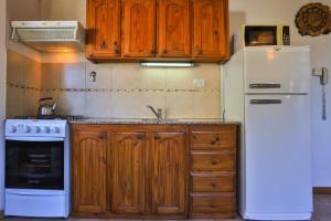圣卡洛斯-德巴里洛切Cascada Del Sur的厨房配有木制橱柜和白色冰箱。