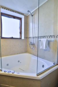 圣卡洛斯-德巴里洛切Cascada Del Sur的带浴缸和玻璃淋浴间的浴室。