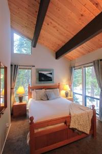 国王海滩Woodsy retreat near Northstar & lake的一间带一张大床的卧室,位于带窗户的房间内