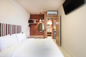 海若克利欧Pavo Art Hotel的卧室配有白色的床和镜子
