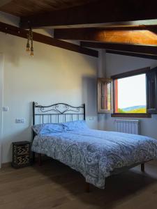 Ambas AguasA Porteliña Casa Rural的一间卧室配有一张带蓝色棉被的床和窗户。