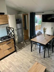 圣西普里安MOBIL-HOME NEUF 2021 3CH 34 M2的一间带桌子的客厅和一间厨房