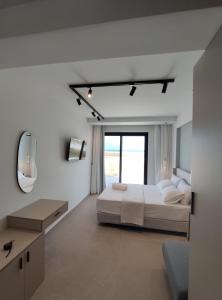 萨尔蒂Onar in Sarti的白色卧室配有床和镜子