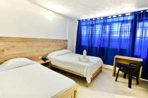辛塞莱霍Hotel Comercial的一间卧室设有两张床、一张桌子和一个窗口。