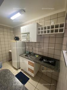 卡达斯诺瓦斯DiRoma Fiori Caldas Novas - YMT - 030的小厨房配有白色橱柜和冰箱。