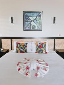 Matatufu萨了托加金沙度假酒店及水疗中心的白色的床,上面装饰着花卉