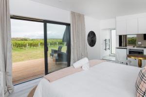 吉斯伯恩Matawhero Wines的一间卧室设有一张床和一个享有美景的大窗户