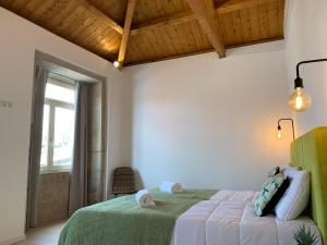 波尔图Lost Inn Porto Hostel的一间卧室设有一张绿色的床和一个窗户。