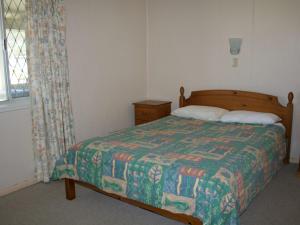 黄金海岸White Dolphin Unit 5的一间卧室配有一张带被子的床和一扇窗户