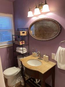 阿比林Cornerhouse, an Abilene Classic的一间带水槽、卫生间和镜子的浴室