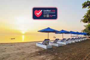 沙努尔尹娜圣德海滨酒店的海滩上的一排椅子和遮阳伞