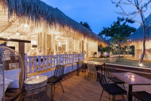 金巴兰Le Yanandra Bali Resort的一间在甲板上配有桌椅的餐厅