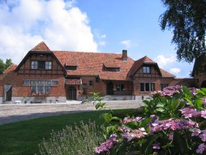 WarnetonCozy Farmhouse with Hill View的一座古老的砖房,前面有鲜花