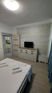 图尔恰Apartament Matei的卧室配有白色的床和电视。