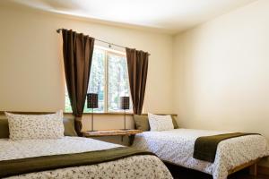 西优胜美地Alpenglow 3的带窗户的客房内的两张床