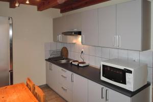 什切青holiday home, Szczecin的厨房配有白色橱柜、水槽和微波炉
