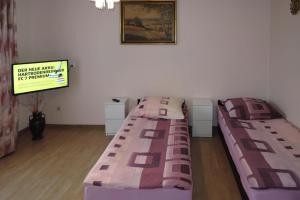 米兹多洛杰holiday home, Miedzyzdroje的配有电视的客房内的两张床