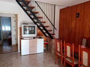 福纽德Napsugar Nyaraló的一间带电视和楼梯的客厅